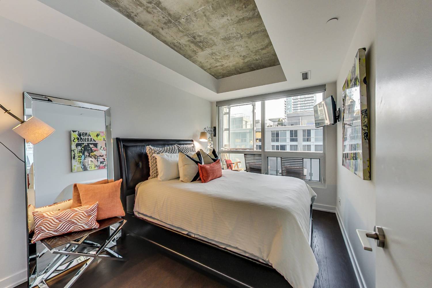 A warm, light-filled bedroom with a downtown Toronto view in a home the team has sold
